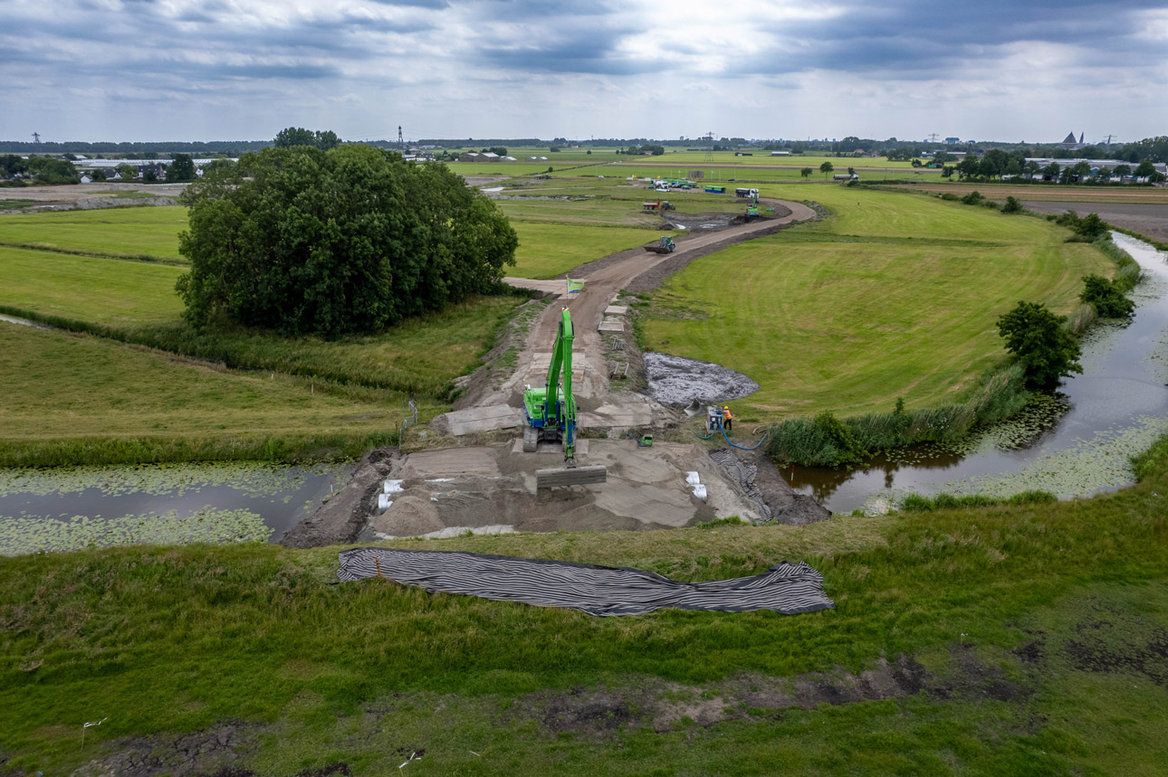 AW machine rijdt over de sloot.