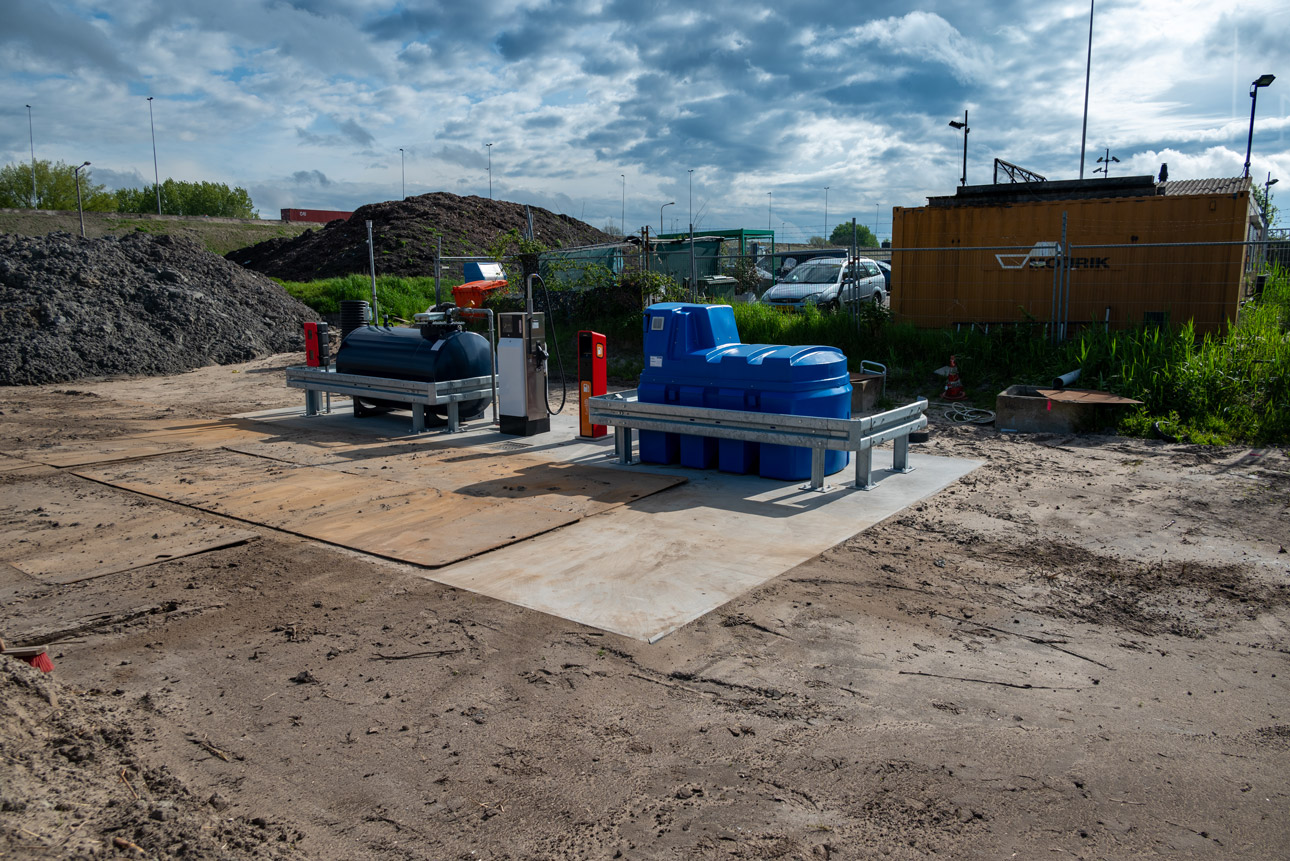 Een blauwe en een zwarte tank op de vloeistofdichte betonvloer.